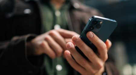 close-up-hands-of-unrecognizable-man-holding-and-using-smartphone-standing-on-city-street-browsing-i.jpeg
